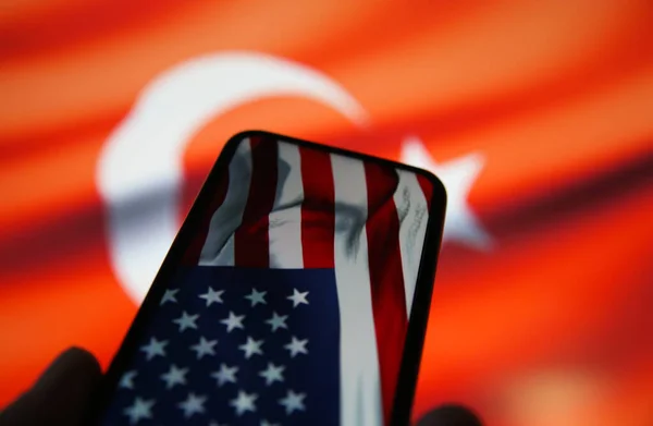 私たちと携帯電話のディスプレイの閉鎖アメリカの旗 トルコのぼやけた旗の背景 — ストック写真