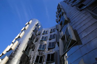 Düsseldorf (Medienhafen), Almanya - 7 Kasım. 2020: Gehry evini gümüş parlak metalik alüminyum cepheli ofislerle birlikte görmek