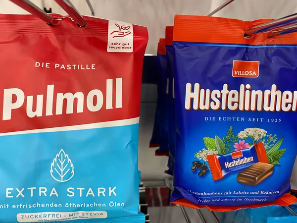 Viersen, Almanya - 9 Kasım. 2020: Alman süpermarketlerinin raflarında izole edilmiş kırmızı Pulmoll ve Hustelinchen öksürük şekeri paketleri