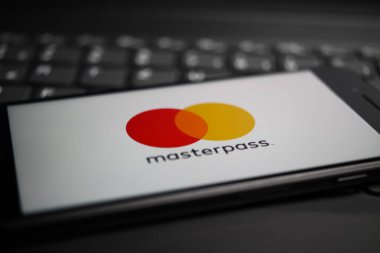 Viersen, Almanya - 9 Nisan. 2020: Cep telefonu ekranının kapatılması ve bilgisayar klavyesindeki ana kart ödeme sağlayıcısının logosu bize dolar para geçmişini bulanıklaştırdı