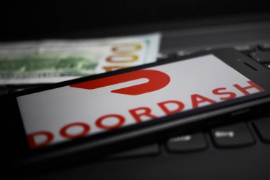 Viersen, Almanya - 9 Nisan. 2020: Cep telefonu ekranının kapatılması ve bilgisayar klavyesinde Doordash ödeme sağlayıcısının logosu bulunuyor