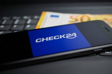 Viersen, Almanya - 9 Nisan. 2020: Cep telefonu ekranının, klavyede Check24 karşılaştırma portalının logosu olan kapatılması, 50 Euro para arkaplanı
