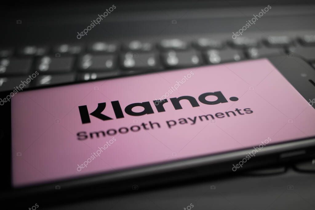 Viersen, Germany - April 9. 2020: Close up of mobile phone screen with logo lettering of Klarna payment provider on computer keyboard