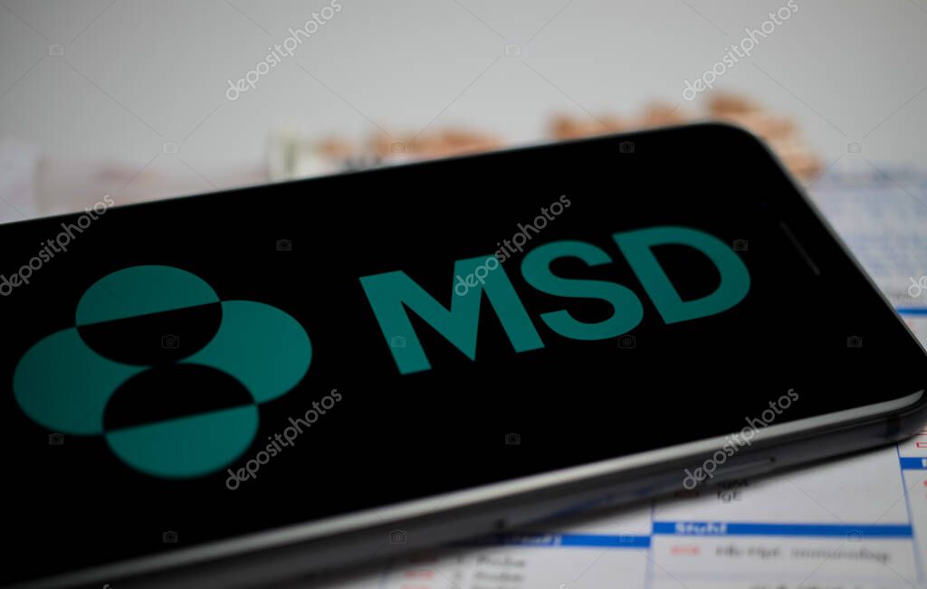 Viersen, Germany - April 9. 2020: Close up of mobile phone screen with logo lettering of MSD Sharp and Dohme pharmaceutical company, blurred pills and lab sheet background