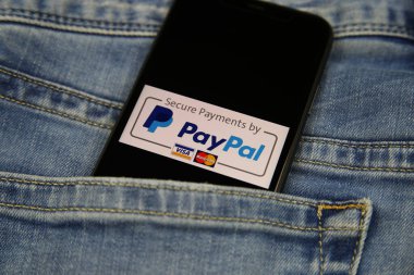 Viersen, Almanya - 9 Kasım. 2020: Kotların cebinde ödeme sağlayıcısı Paypal logosu bulunan izole edilmiş cep telefonunu kapat