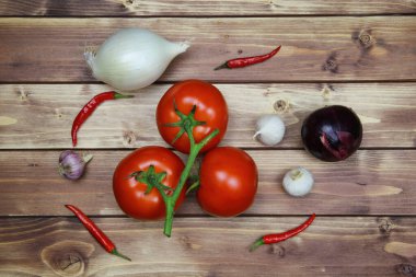 Çiğ, beyaz, kırmızı soğan, domates, sarmaşık ve biber. Kahverengi kırsal ahşap arka plan. Baharatlı domates salatası için sağlıklı malzemeler..
