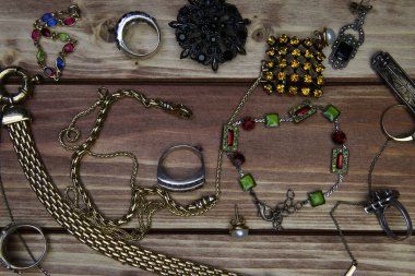 Ahşap masadaki izole edilmiş altın ve gümüş mücevher parçalarının yukarıdan görünüşü