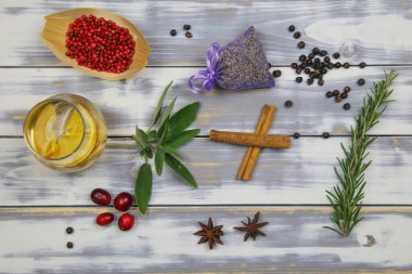 Cin tonik camlı, kırmızı biberli, lavantalı, biberiyeli, adaçaylı, kızılcıklı, anason botanikli beyaz kereste sehpasında tepeden aşağı görüş.
