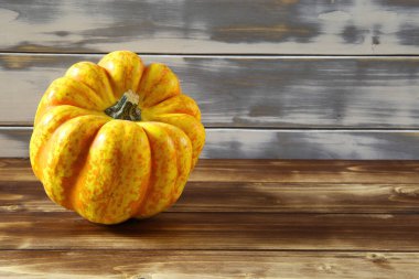 İzole edilmiş parlak sarı turuncu olgun balkabağına yakın beyaz ve kahverengi ahşap ahşap kaplama arka plan