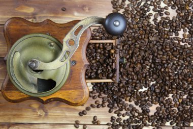 Eski, izole edilmiş eski el kitabında tepeden tırnağa kahverengi ahşap masa üzerinde çiğ fasulye yığınıyla klasik kahve öğütücüsü.