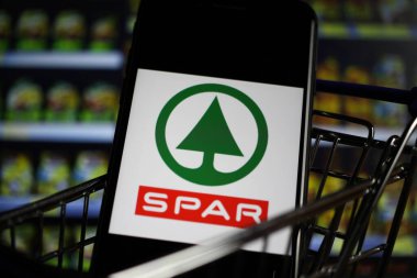Viersen, Almanya - 9 Mayıs. 2020: Alman Spar süpermarket zincirinin logo harfleriyle alışveriş arabasındaki cep telefonu ekranını kapat