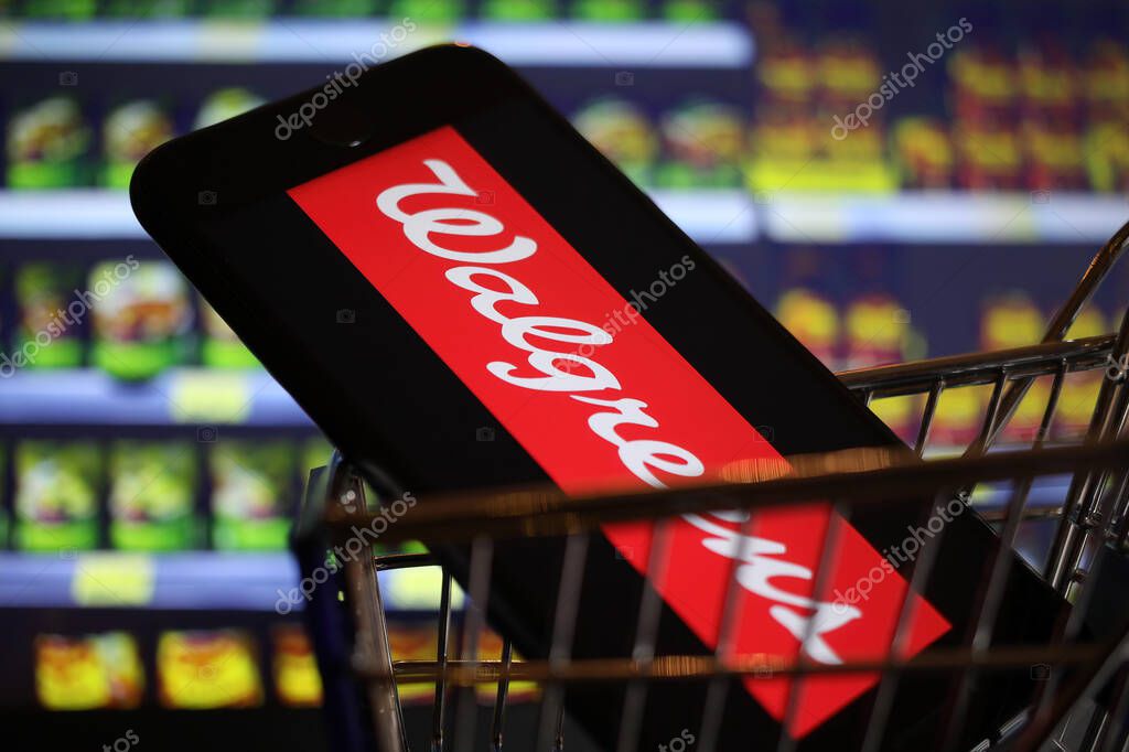 Viersen, Germany - May 9. 2020: Close up of mobile phone screen in shopping cart modell with logo lettering of us american Walgreens supermarket chain (focus on center of lidl logo)