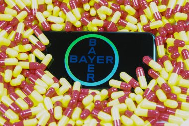 Viersen, Almanya - 9 Nisan. 2020: Kırmızı ilaç kapsülleri üzerinde Bayer ilaç şirketinin logosu olan cep telefonu ekranını kapat (harf merkezine odaklan)