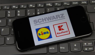 Viersen, Almanya - 9 Mayıs. 2020: Laptop klavyesindeki cep telefonunun Alman Schwarz grubunun logosu ile kapatılması