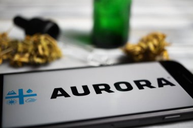 Viersen, Almanya - 9 Ocak. 2021: Cep telefonu ekranının kapatılması, kenevir şirketi Aurora keneviri, bulanık marihuana ve pipette arkaplan logosu