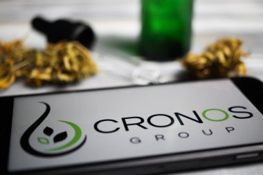 Viersen, Almanya - 9 Ocak. 2021: Cep telefonu ekranının kapatılması, Cannabinoid şirketi cronos grubunun logosu, bulanık marihuana ve pipo arkaplanı