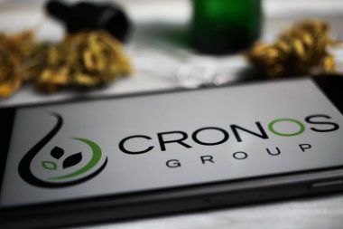 Viersen, Almanya - 9 Ocak. 2021: Cep telefonu ekranının kapatılması, Cannabinoid şirketi cronos grubunun logosu, bulanık marihuana ve pipo arkaplanı