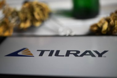 Viersen, Almanya - 9 Ocak. 2021: Cep telefonu ekranının kapatılması, Cannabinoid şirketi Tilray 'in logosu, bulanık marihuana ve pipo arka planı