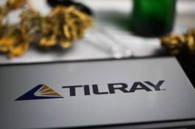 Viersen, Almanya - 9 Ocak. 2021: Cep telefonu ekranının kapatılması, Cannabinoid şirketi Tilray 'in logosu, bulanık marihuana ve pipo arka planı
