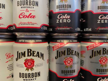 Viersen, Germany - January 9. 2020: Closeup of cans with Jim Beam mixed cola drinks in shelf of german supermarket (focus on central bottle)