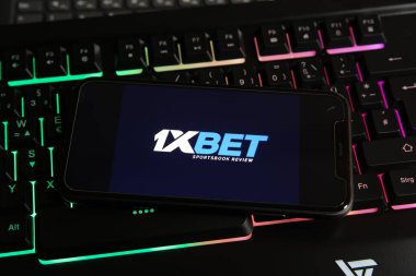 Viersen, Almanya - 9 Ocak. 2021: Bilgisayar klavyesinde online bahis sağlayıcı 1xbet logosu bulunan akıllı telefon ekranının kapatılması