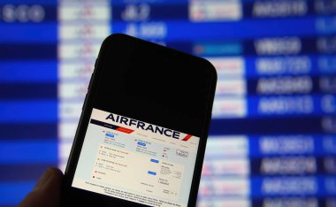Viersen, Almanya - 9 Şubat. 2021: Air France rezervasyon uygulaması ve bulanık varış tahtası arka planıyla cep telefonu ekranının kapatılması