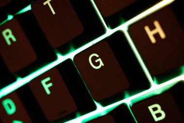 Bilgisayar klavyesinin yeşil sarı ışıklı anahtarlarının makro yakın plan görüntüsü (G harfine odaklan)