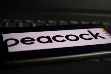 Viersen, Almanya - 1 Mart. 2021: Bilgisayar klavyesinde çevrimiçi yayın yapan tavus kuşunun logosu olan akıllı telefon ekranının kapatılması