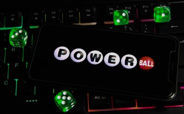Viersen, Germany - March 1. 2021: Closeup of smartphone with logo letterin of american powerball powerplay lottery game on computer keyboard clipart