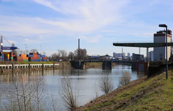Krefeld (Uerdingen) - 1 Mart. 2021: Mavi gökyüzüne karşı vinç, su yolu teknesi ve fabrika binasıyla nehir ren kıyısındaki eski iç kesimlere bakın.
