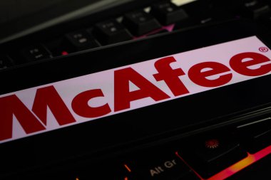 Viersen, Germany - March 1. 2021: Closeup of mobile phone with logo lettering of mcafee anti virus computer security software on keyboard clipart