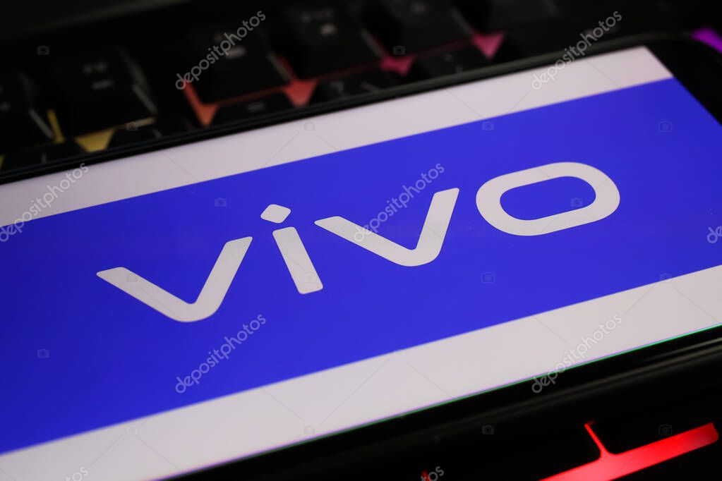 Viersen, Germany - March 1. 2021: Closeup of smartphone screen with logo lettering of chinese vivo mobile phone company on computer keyboard
