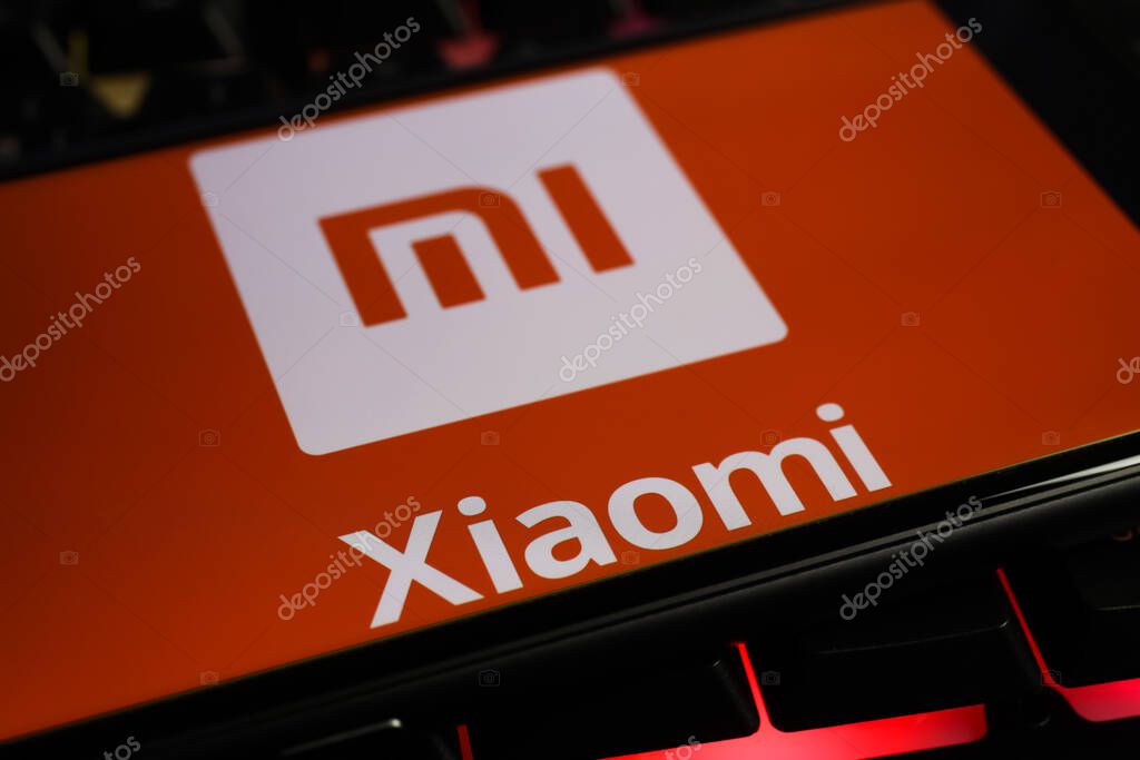 Viersen, Germany - March 1. 2021: Closeup of smartphone screen with logo lettering of chinese xiaomi mobile phone company on computer keyboard