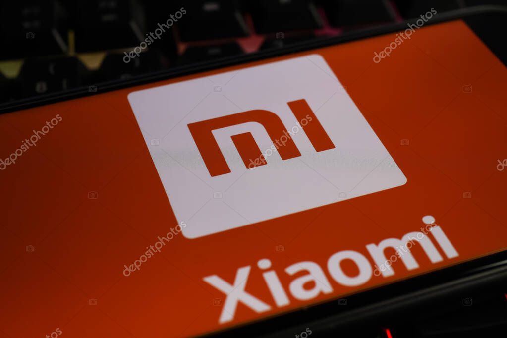 Viersen, Germany - March 1. 2021: Closeup of smartphone screen with logo lettering of chinese xiaomi mobile phone company on computer keyboard