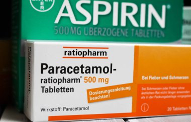 Viersen, Almanya - 1 Mart. 2021: Ahşap masa üzerinde parasetamol ve aspirin ağrı kesici haplarının yakınlaştırılması