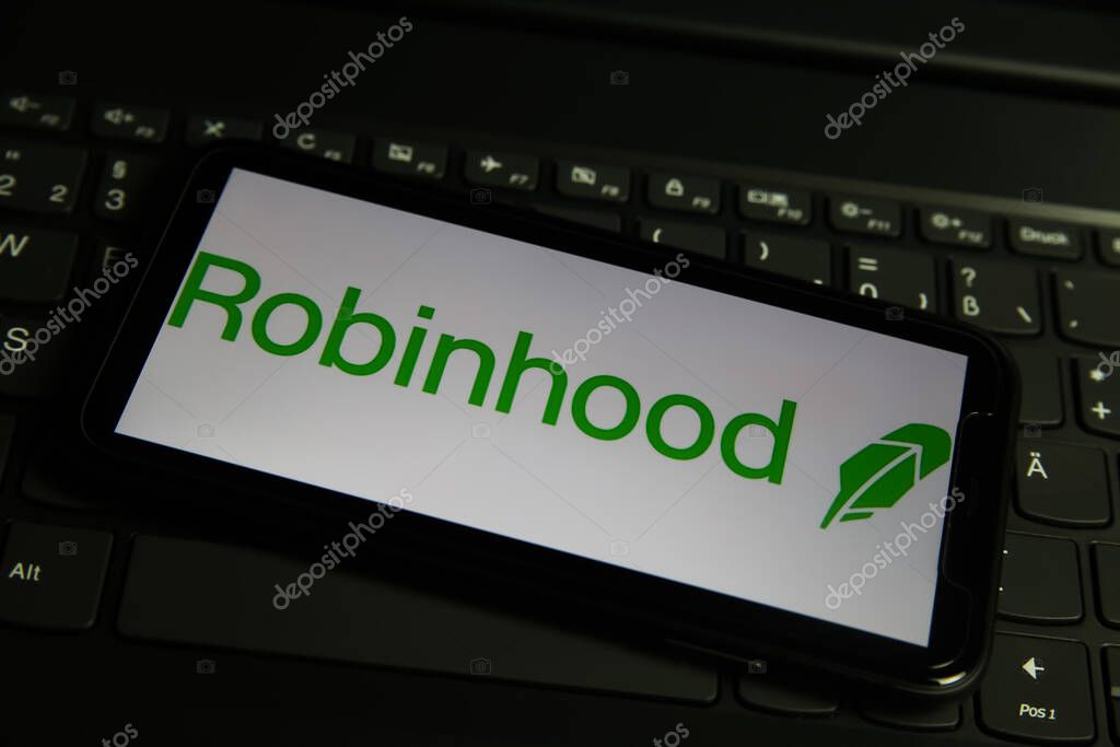 Viersen, Germany - March 1. 2021: Closeup of mobile phone screen with logo lettering of robinhood online broker service on computer keyboard