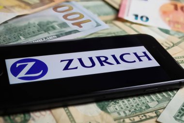 Viersen, Germany - March 1. 2021: Closeup of smartphone with logo lettering of zurich insurance company on paper money currency