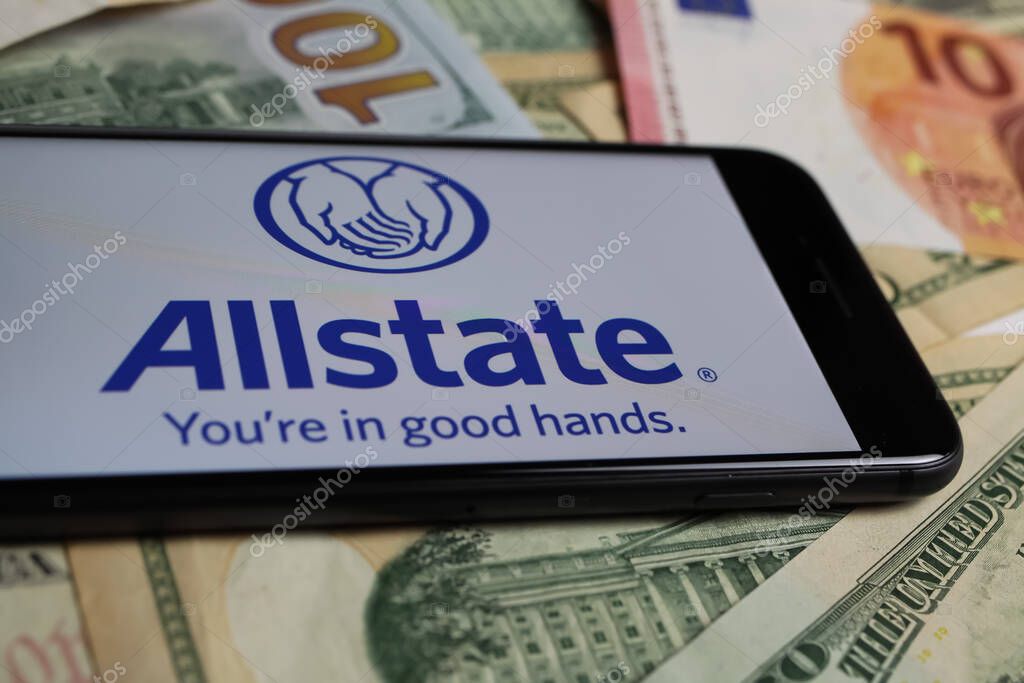 Viersen, Germany - March 1. 2021: Closeup of smartphone with logo lettering of allstate insurance company on paper money currency