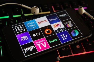 Viersen, Almanya - 1 Mart. 2021: Cep telefonu ekranının kapatılması ve dizüstü bilgisayar klavyesinde çeşitli TV film yayın hizmetlerinin logosu