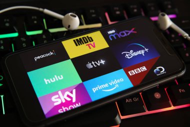 Viersen, Almanya - 1 Mart. 2021: Cep telefonu ekranının kapatılması ve dizüstü bilgisayar klavyesinde çeşitli TV film yayın hizmetlerinin logosu