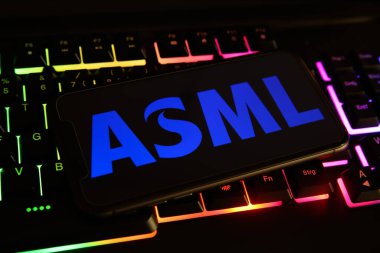 Viersen, Almanya - 1 Mayıs. 2021: Cep telefonu ekranının kapatılması ve bilgisayar klavyesinde asml logosu tutulması