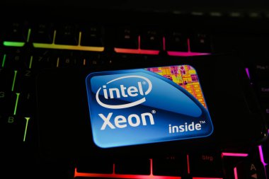Viersen, Germany - May 8. 2021: Closeup of smartphone with logo lettering of intel xeon processor cpu on computer keyboard clipart