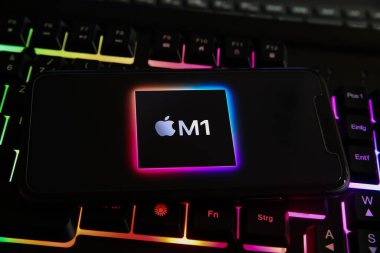 Viersen, Almanya - 8 Mayıs. 2021: Bilgisayar klavyesinde elmalı M1 işlemci işlemcisinin logosu olan akıllı telefonun kapatılması