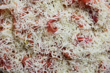 İzole edilmemiş çiğ ev yapımı taze pizza, temel malzemeler domates sosu, serrano jambonu ve rendelenmiş pecorino peyniri.