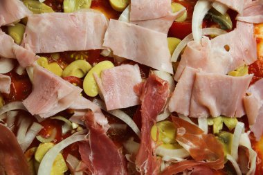 İzole edilmemiş çiğ ev yapımı taze pizza, temel malzemeler domates sosu, soğan, şampiyonlar, serrano ve haşlanmış jambon.