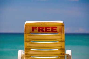 Free isolated empty beach chair on tropical island with panoramic view on horizon over turquoise water - cheap all inclusive package tour vacation concept clipart