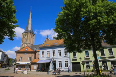 Viersen (Suchteln), Almanya - 20 Mayıs. 2021: Kilise kulesi geçmişi olan ortaçağ evleri ve dükkanları