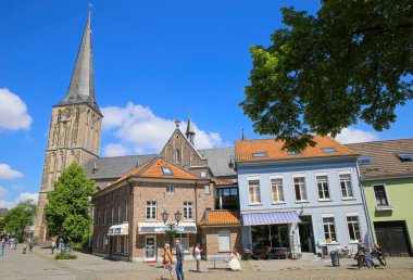 Viersen (Suchteln), Almanya - 20 Mayıs. 2021: Kilise kulesi geçmişi olan ortaçağ evleri ve dükkanları