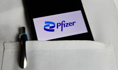 Viersen, Almanya - 9 Mayıs. 2021: Cep telefonu ekranının kapatılması ve Pfizer eczacılık şirketinin logosu beyaz doktor önlüğünün cebinde.