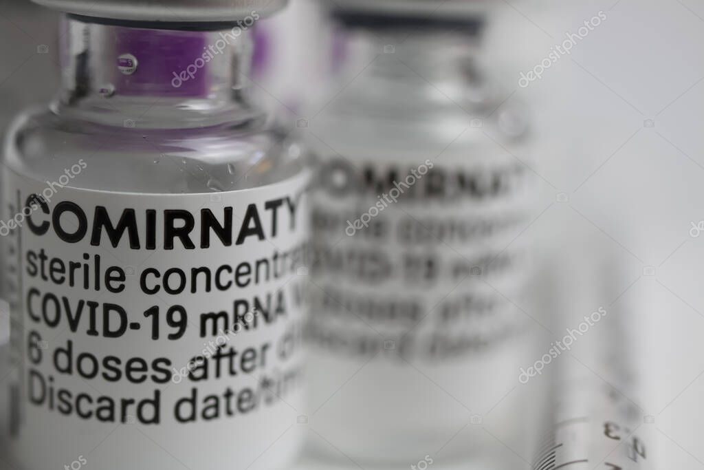 Viersen, Germany - June 9. 2021: Macro closeup of isolated biontech pfizer mrna covid-19 vaccine vials concentrate comirnaty